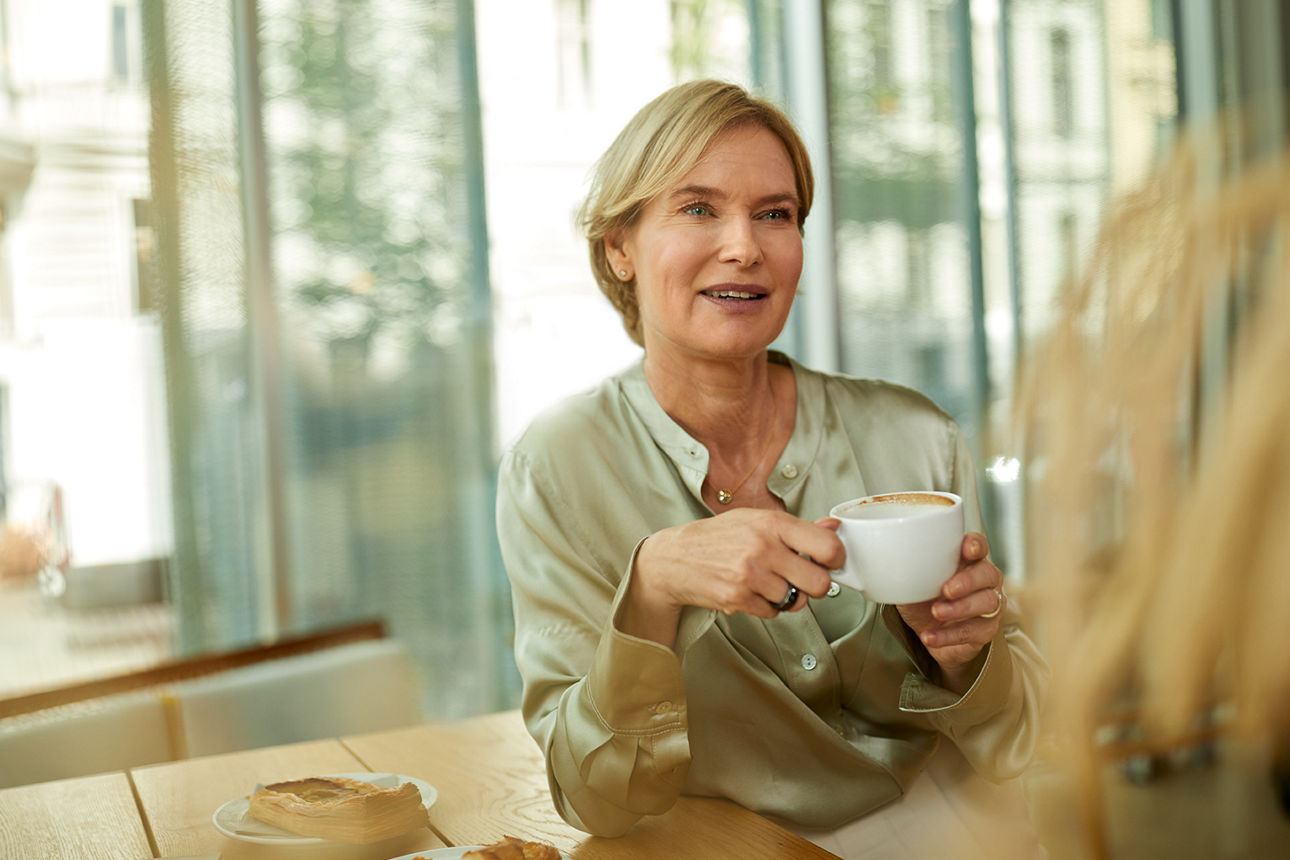 Ältere Frau mit Kaffee in der Hand