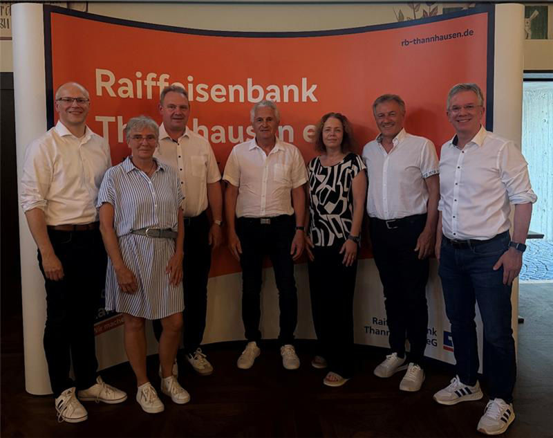 Eine Gruppe von sieben Personen, die vor einem Banner der Raiffeisenbank Thannhausen für ein Foto posieren.