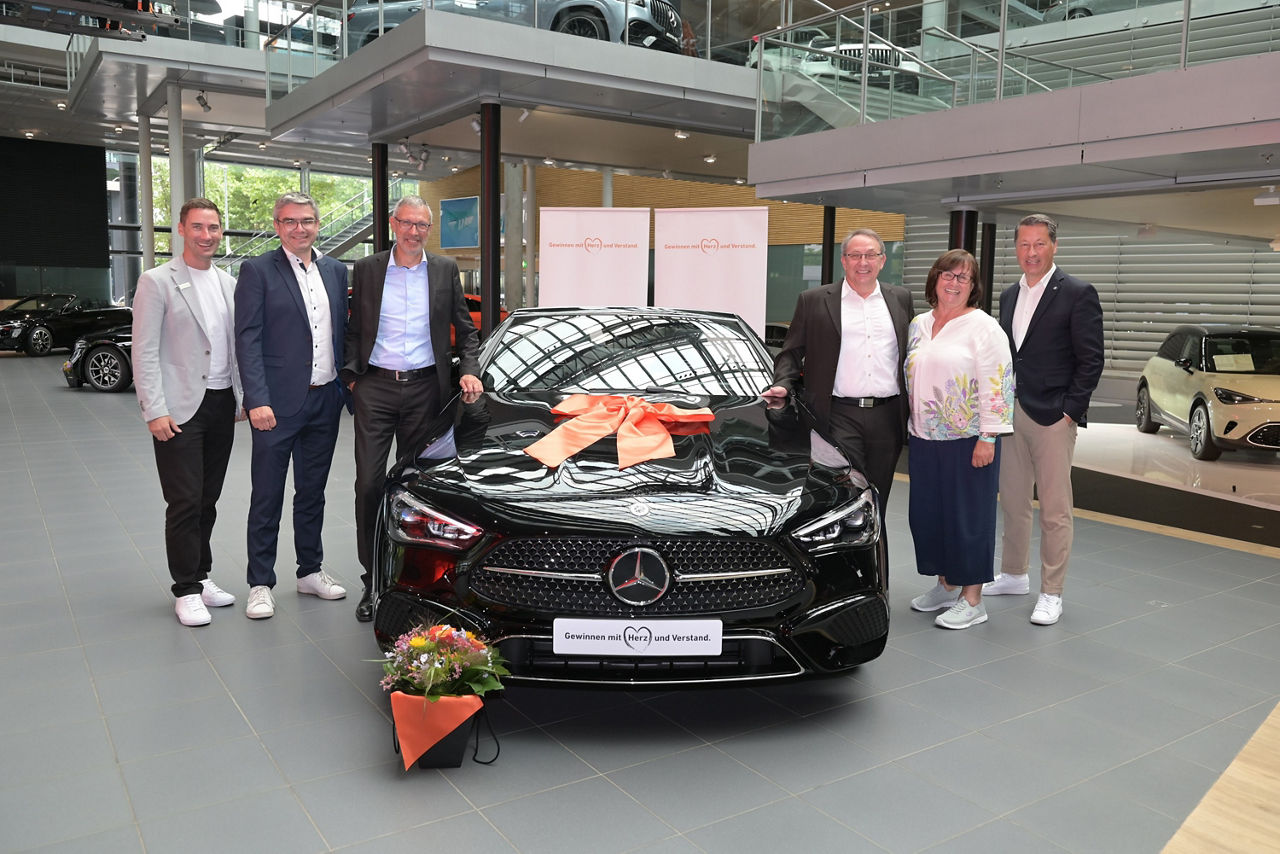Foto von einem Mercedes-Benz CLE-Cabriolet und 6 Personen in einer Halle