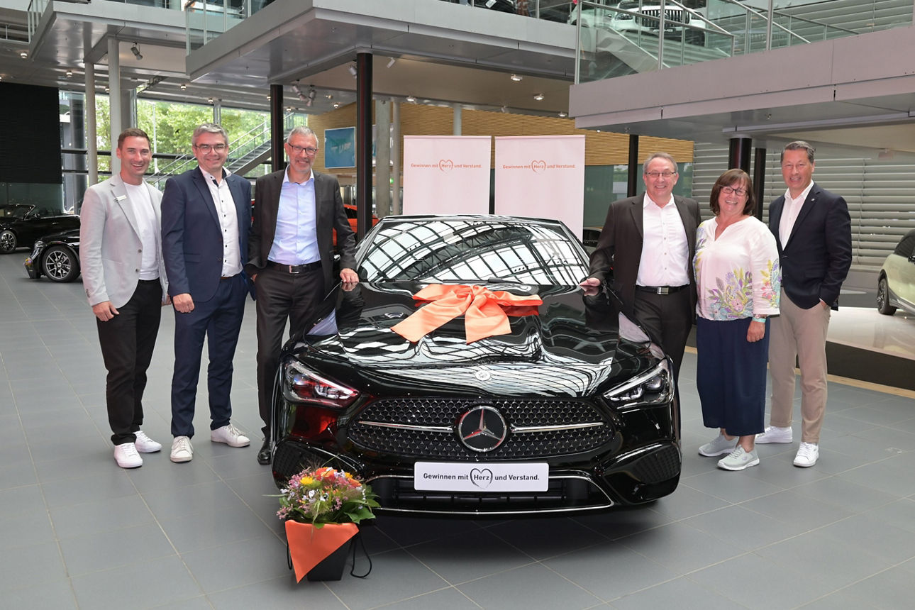 Foto von einem Mercedes-Benz CLE-Cabriolet und 6 Personen in einer Halle