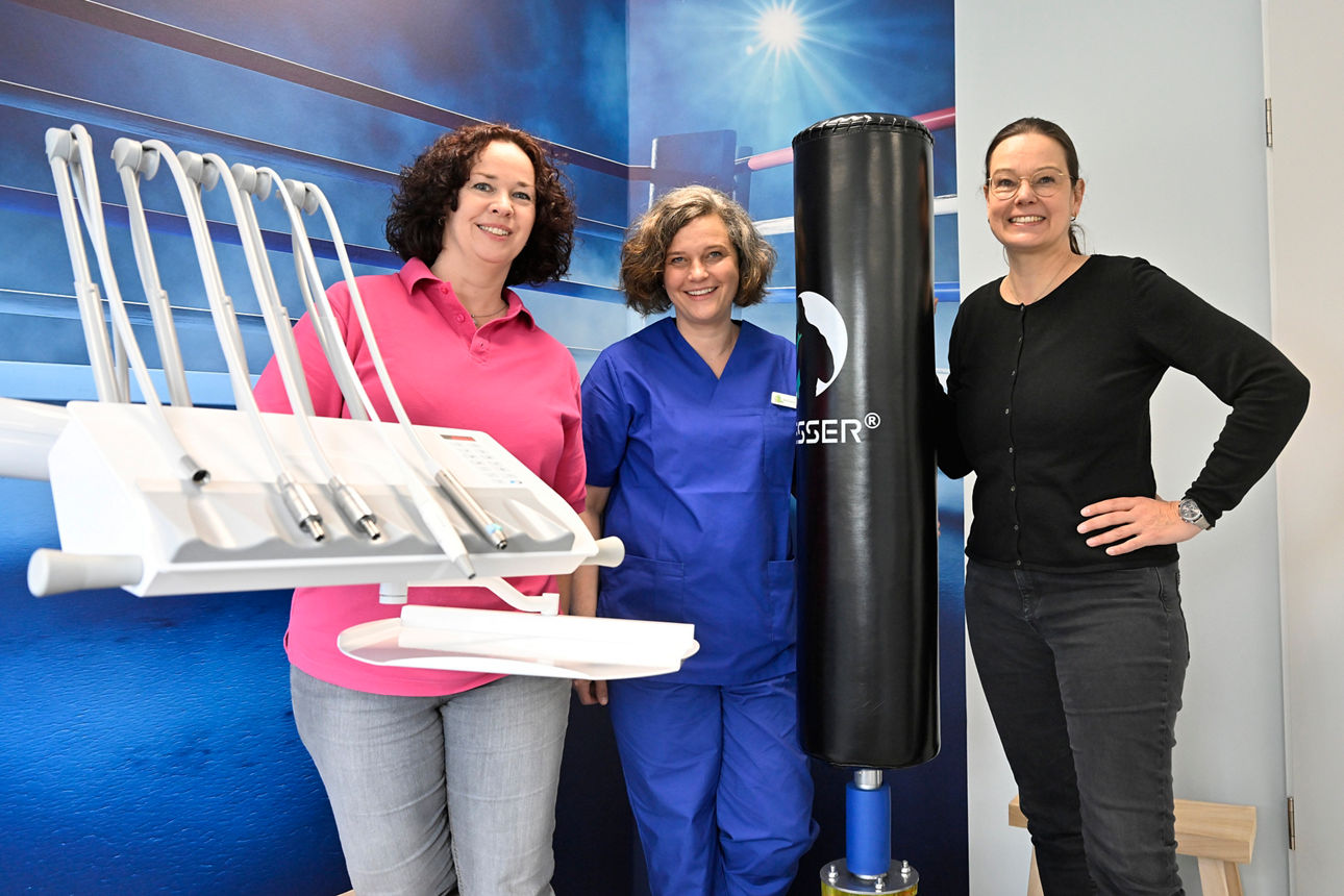 Drei Frauen stehen in einem Zahnarztpraxiszimmer