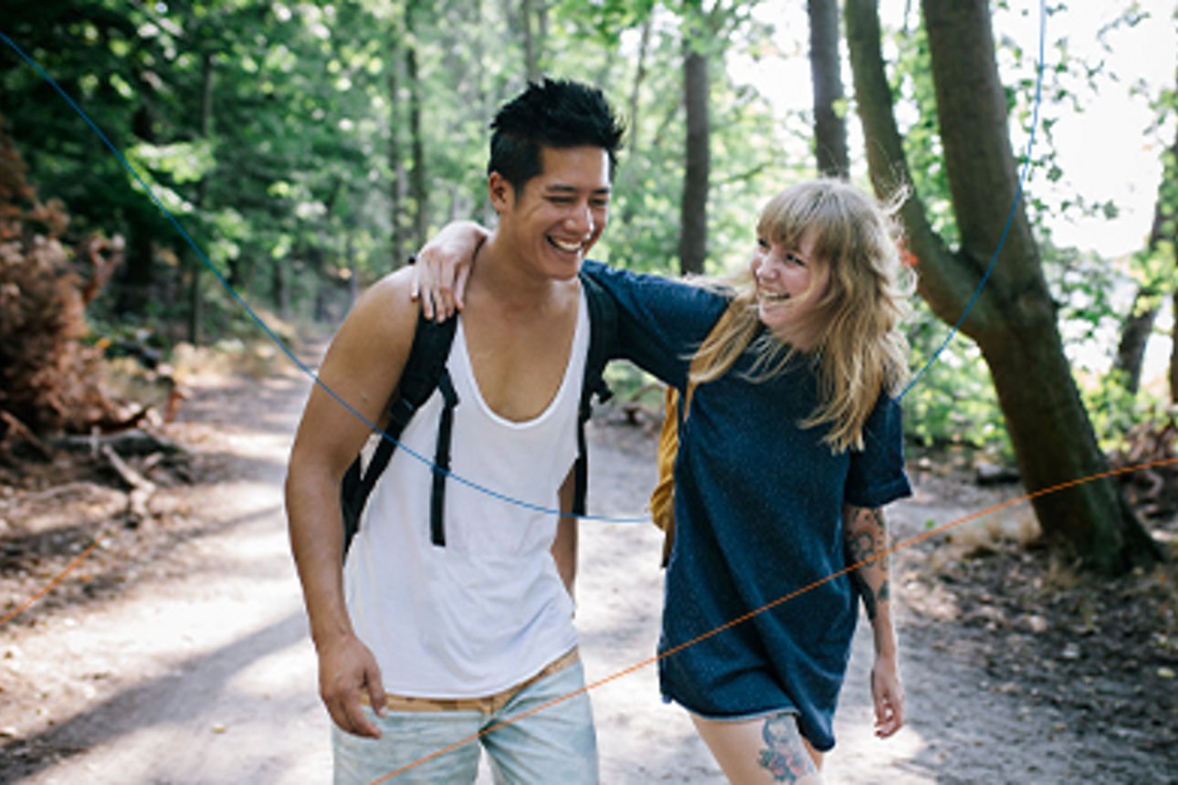Paar bei einem Waldspaziergang freut sich über das neue Konto bei der Sparda-Bank Berlin