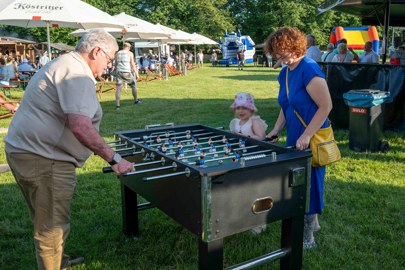 Großeltern mit Enkel am Tischkicker
