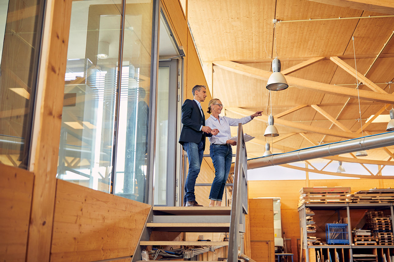 Ein Mann und eine Frau stehen in der Halle und besprechen sich