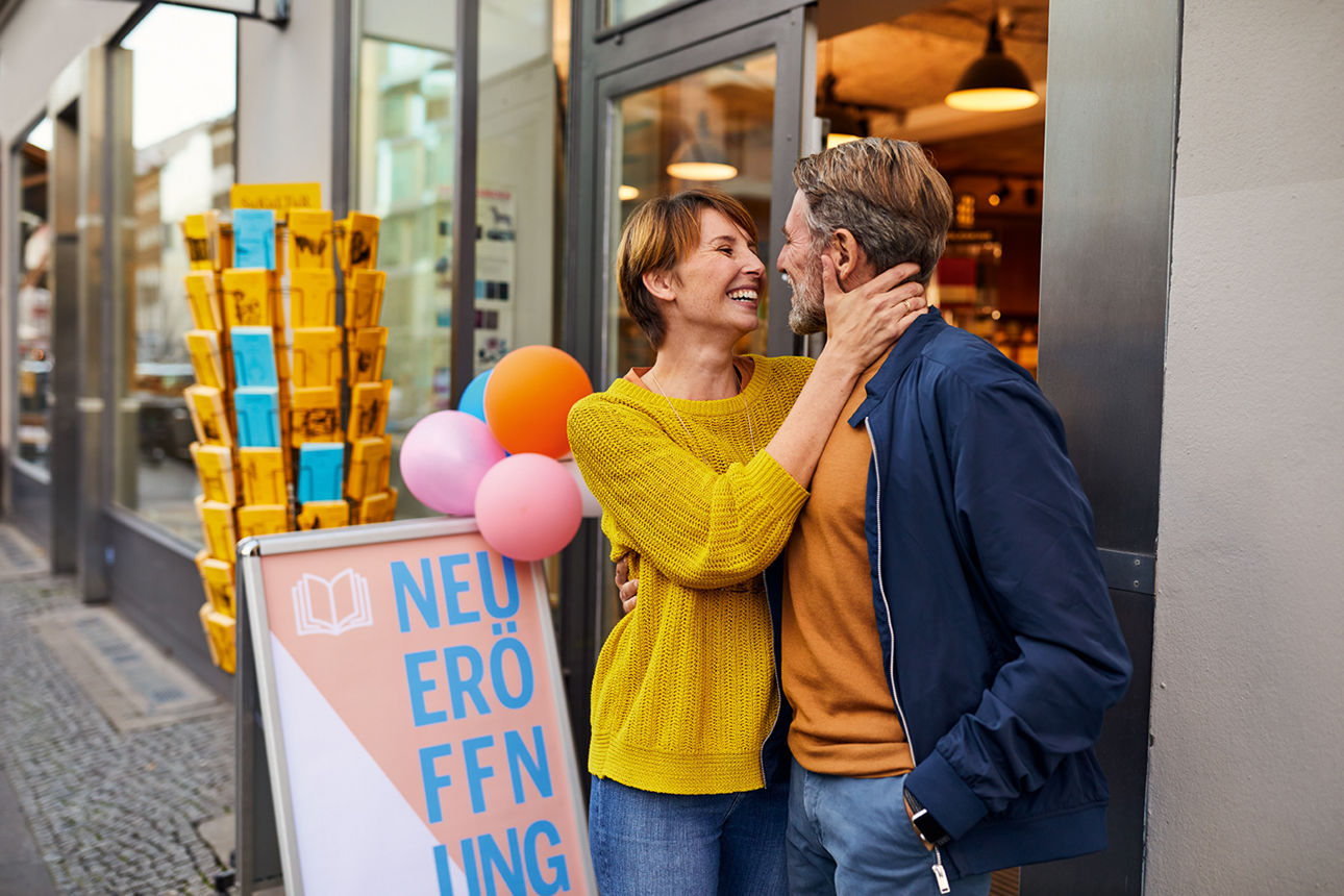 Paar steht für der Neueröffnung einer Buchhandlung Arm in Arm