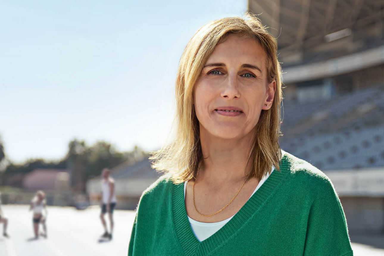 Eine Frau in Porträtaufnahme; im Hintergrund ein Sportstadium