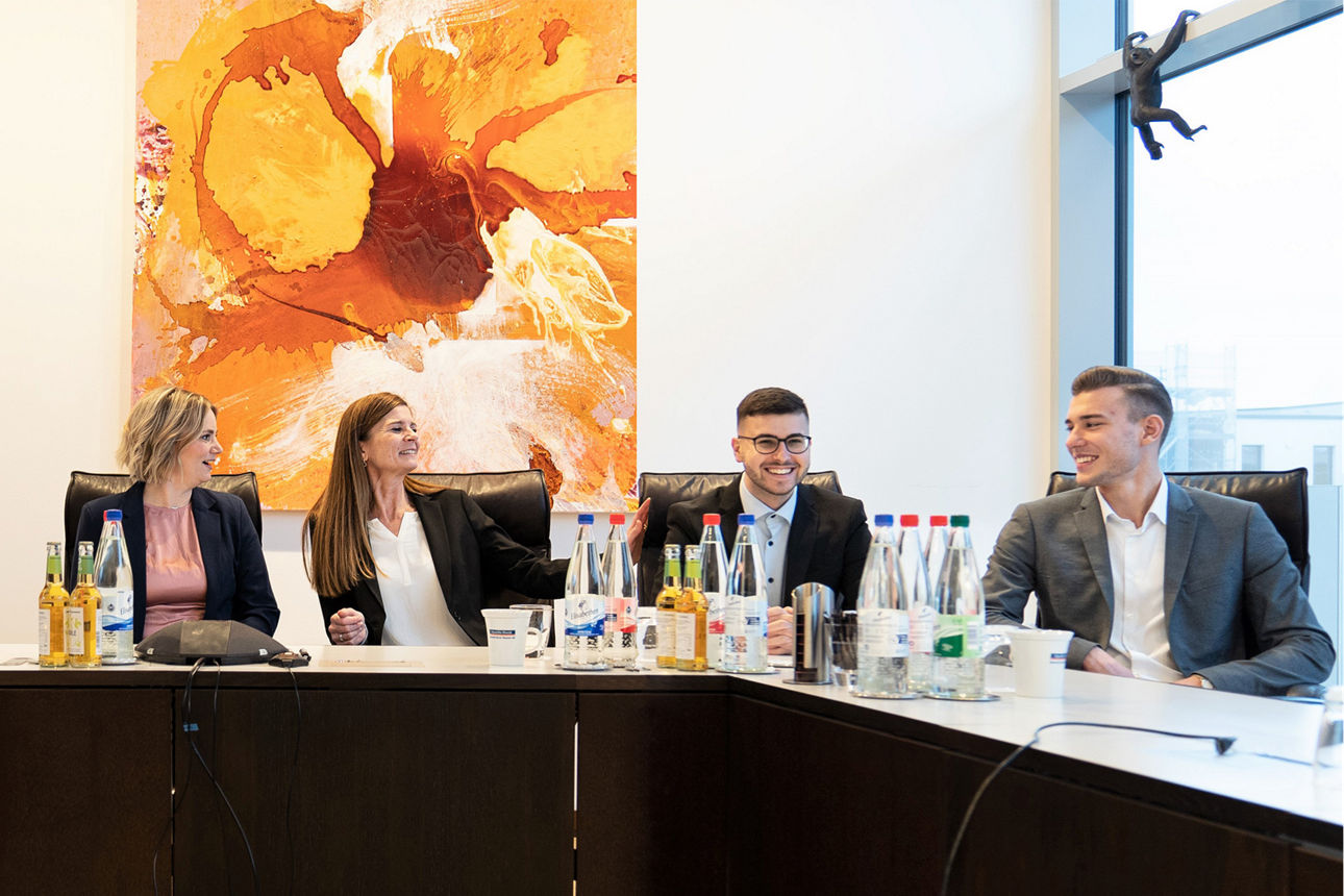 Ausbilderinnnen und Azubis an Tischen in U-Form