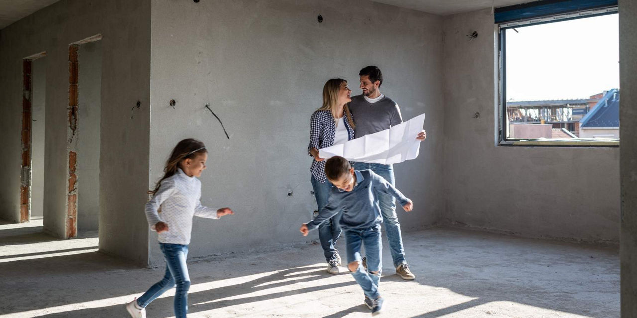 Junge Familie spielt in den Rohbauwänden ihres eigenen Hauses
