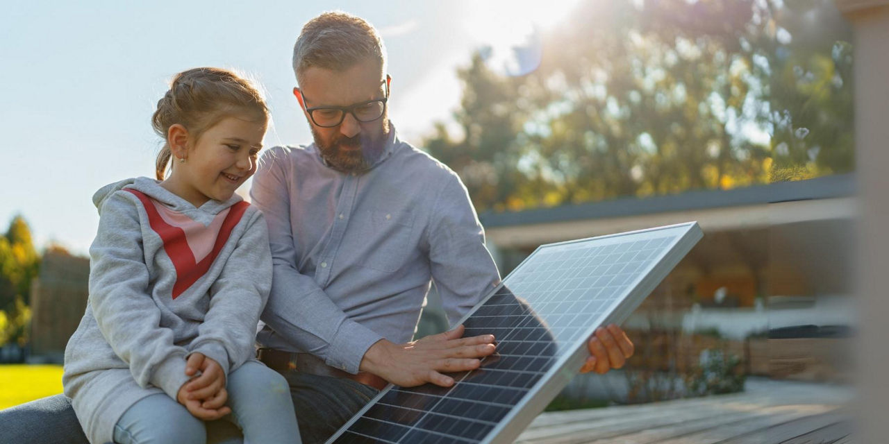 Vater betrachtet zusammen mit seiner Tochter das neue Solarpanel