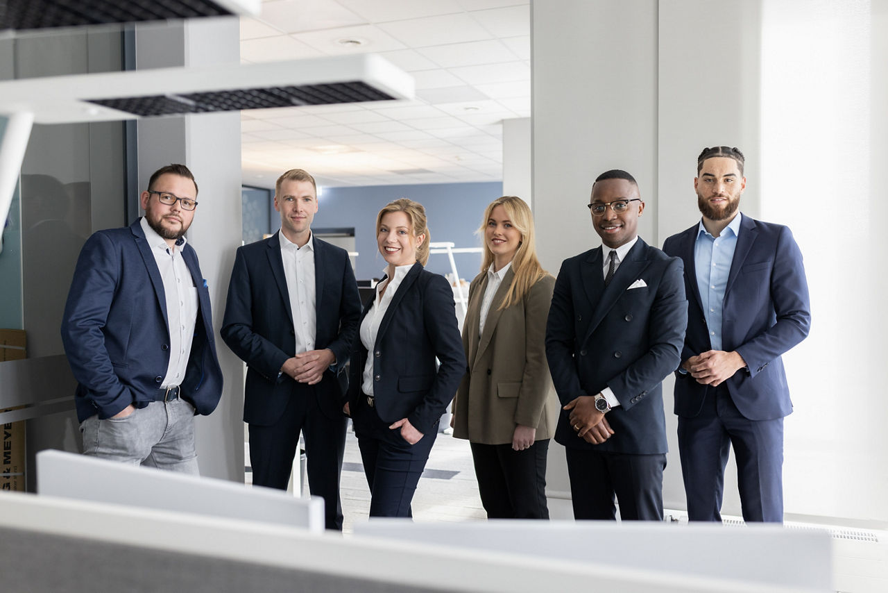 Mitarbeitende stehen in einem Büro