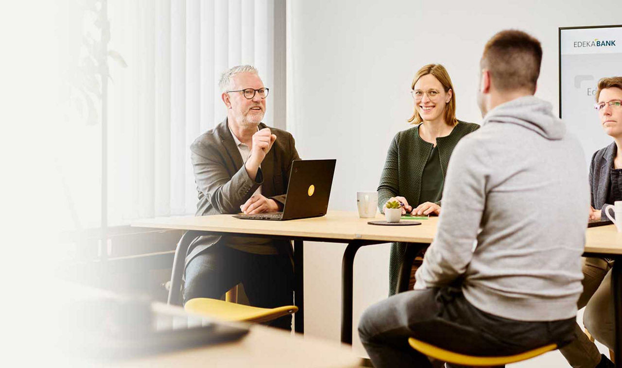Über Uns Kollegen sitzen am Tisch und unterhalten sich