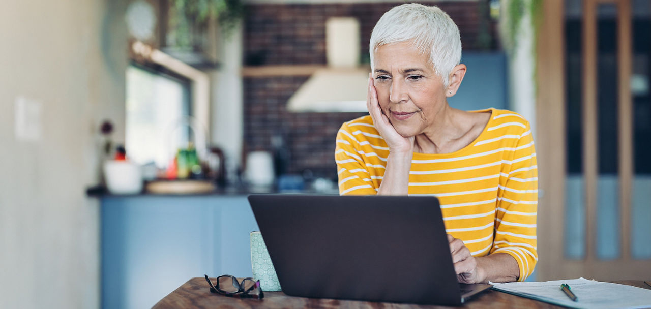 Eine Seniorin schaut auf einen Laptop