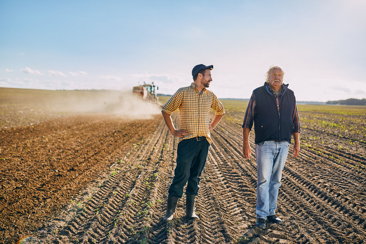 Zwei Landwirte stehen auf einem Acker
