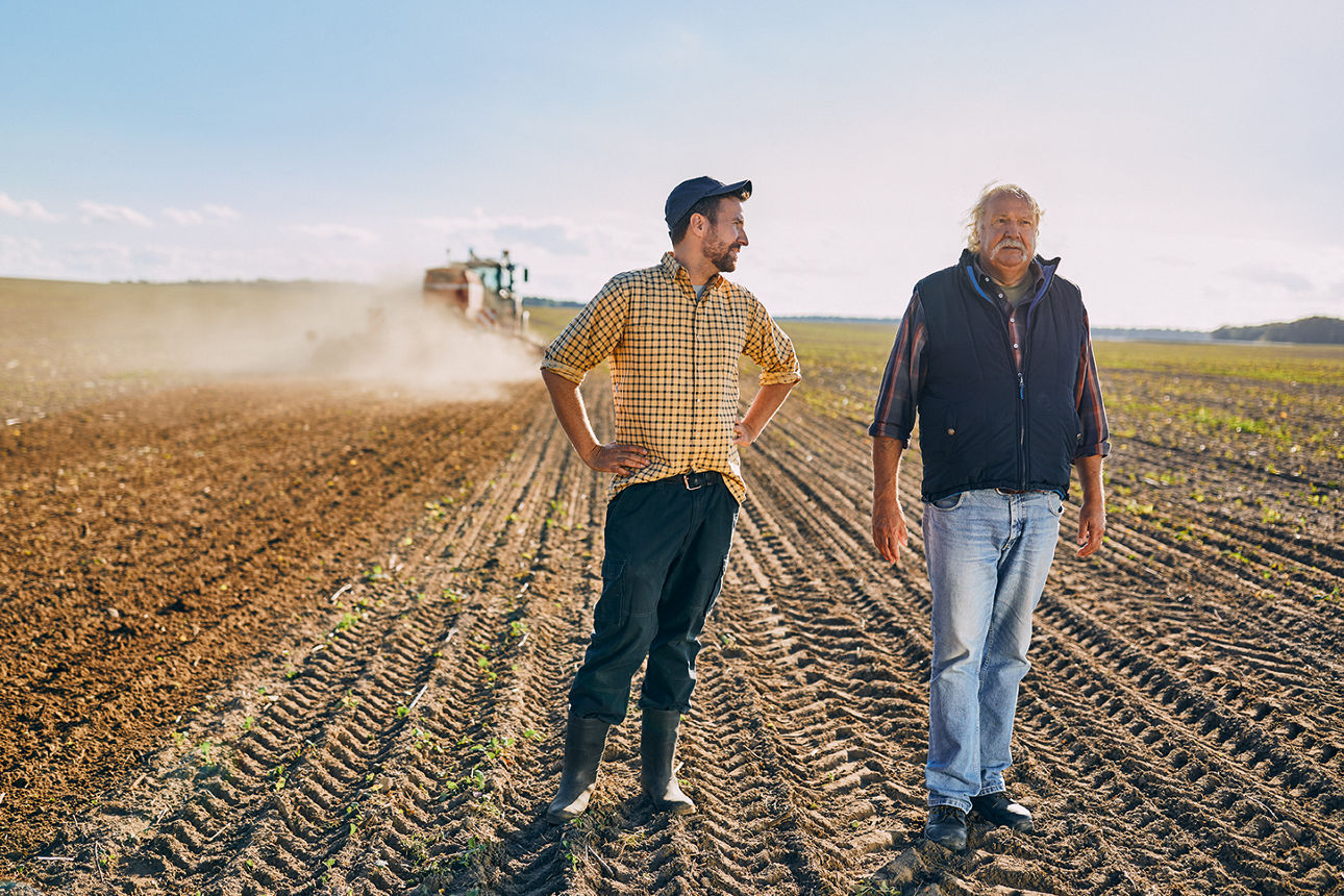 Zwei Landwirte stehen auf einem Acker