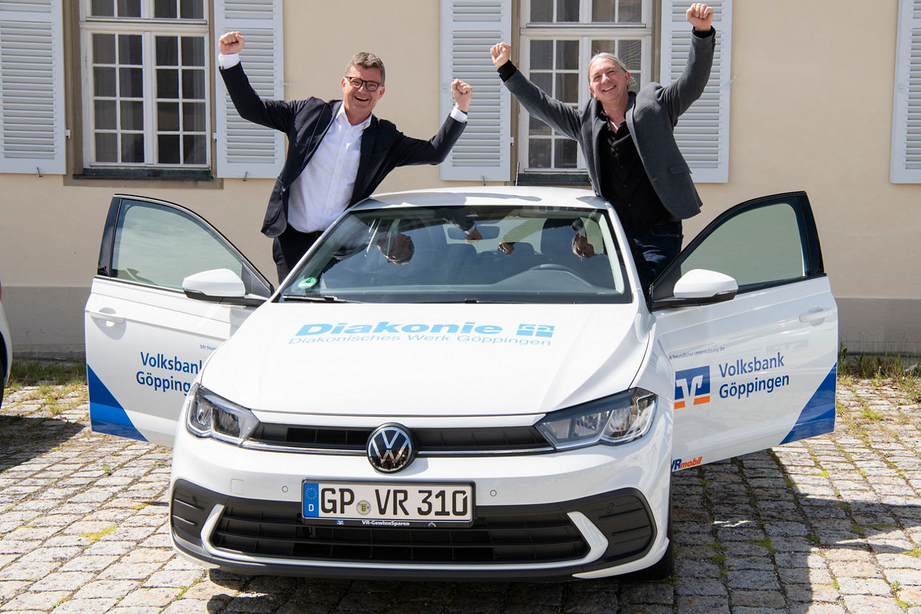 Zwei Männer jubeln aus einem Auto heraus