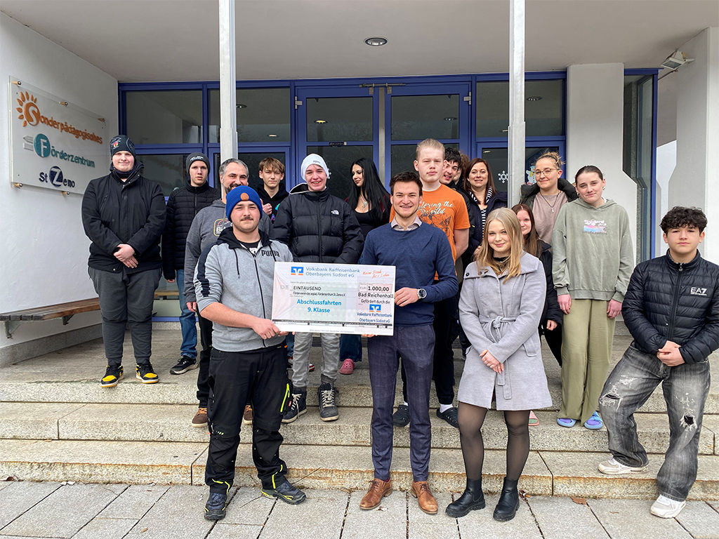 Filialleiter Tobias Nitzinger und Auszubildende Fiona Hainz übergeben den Spendenscheck an Schüler