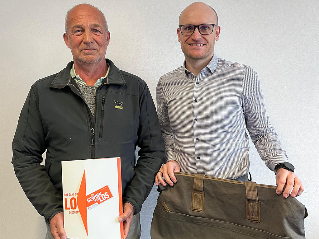 Filialleiter Michael Fernsebner übergibt den Reisegutschein an den glücklichen Gewinner in Siegsdorf.