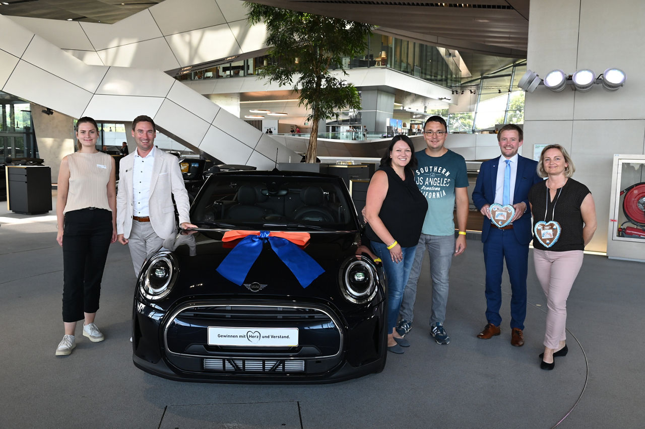 Übergabe eines neuen, schwarzen Mini Coopers an die Gewinnerin vom Gewinnsparen