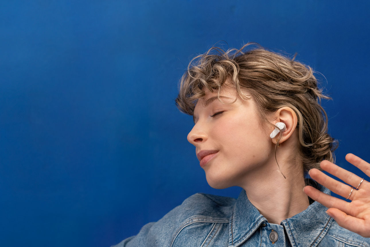Eine junge Frau hört Musik mit In Ear Kopfhörern