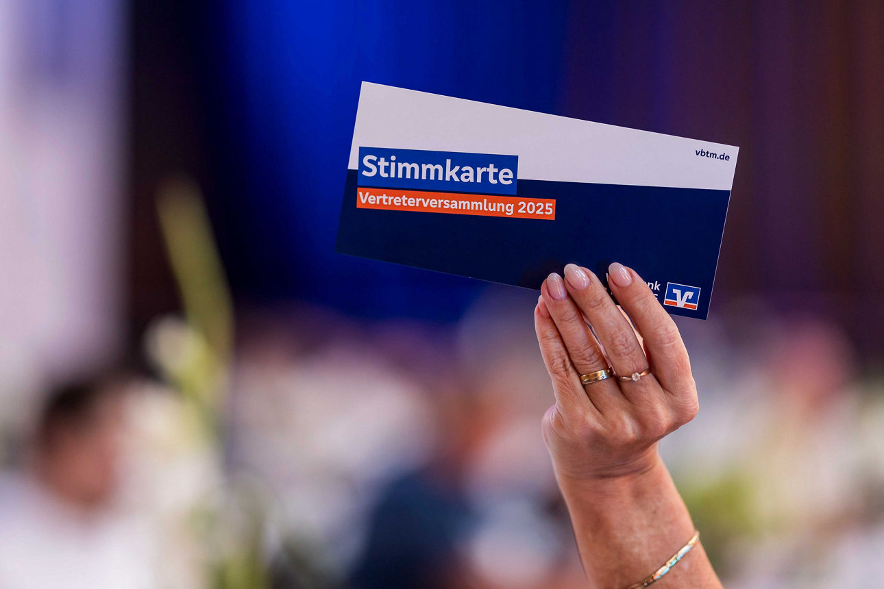 Foto mit Stimmkarte die hochgehalten wird