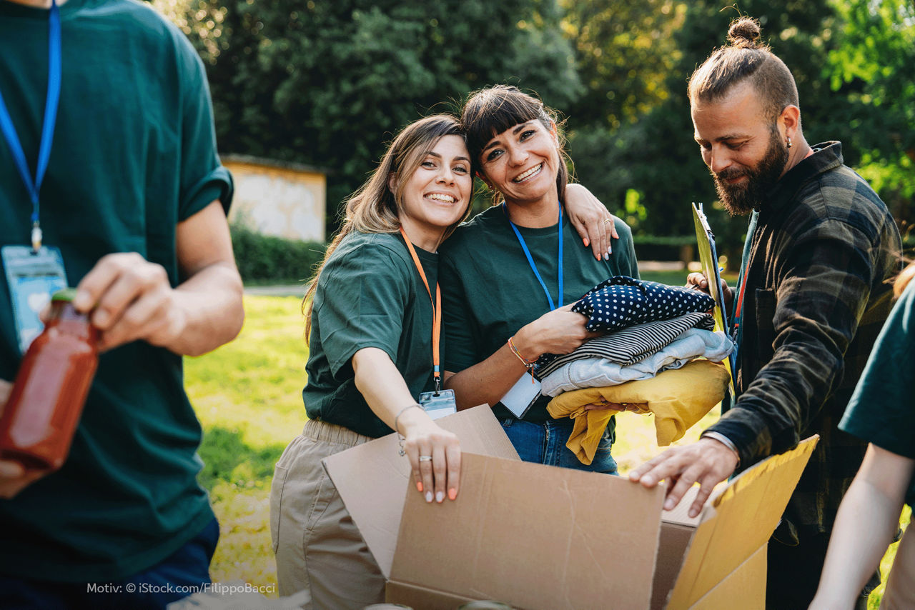 Diverse junge Menschen einer Organisation, die einen Karton packen.