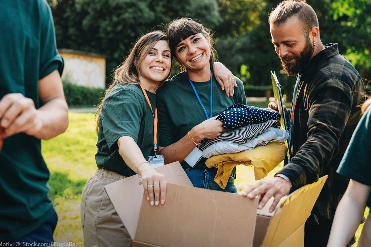Diverse junge Menschen einer Organisation, die einen Karton packen.