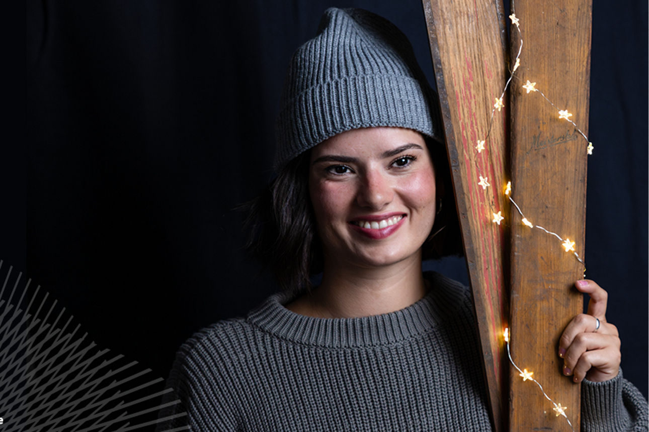 Junge Frau mit Mütze Skiern und Lichterkette