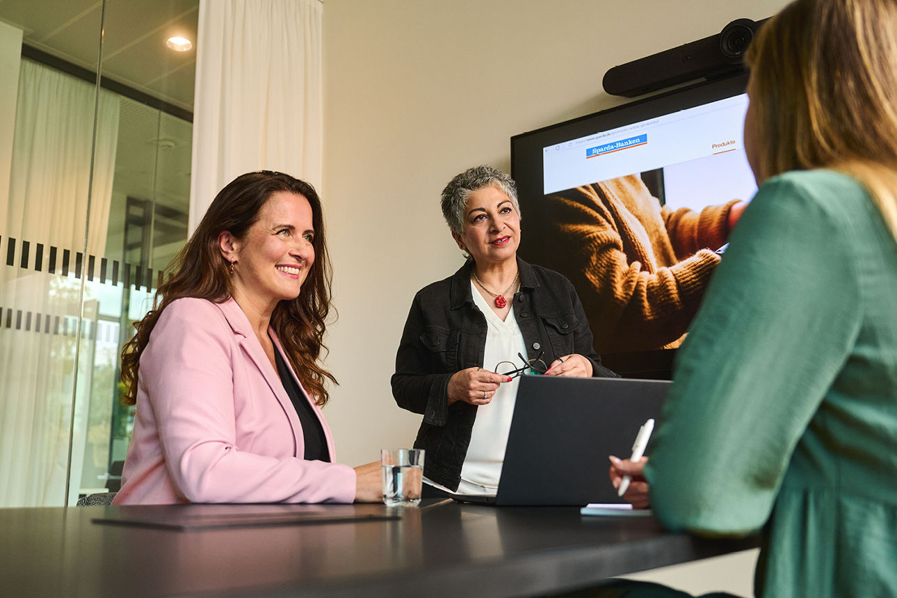 Vier junge Leute sitzen vor einem Laptop