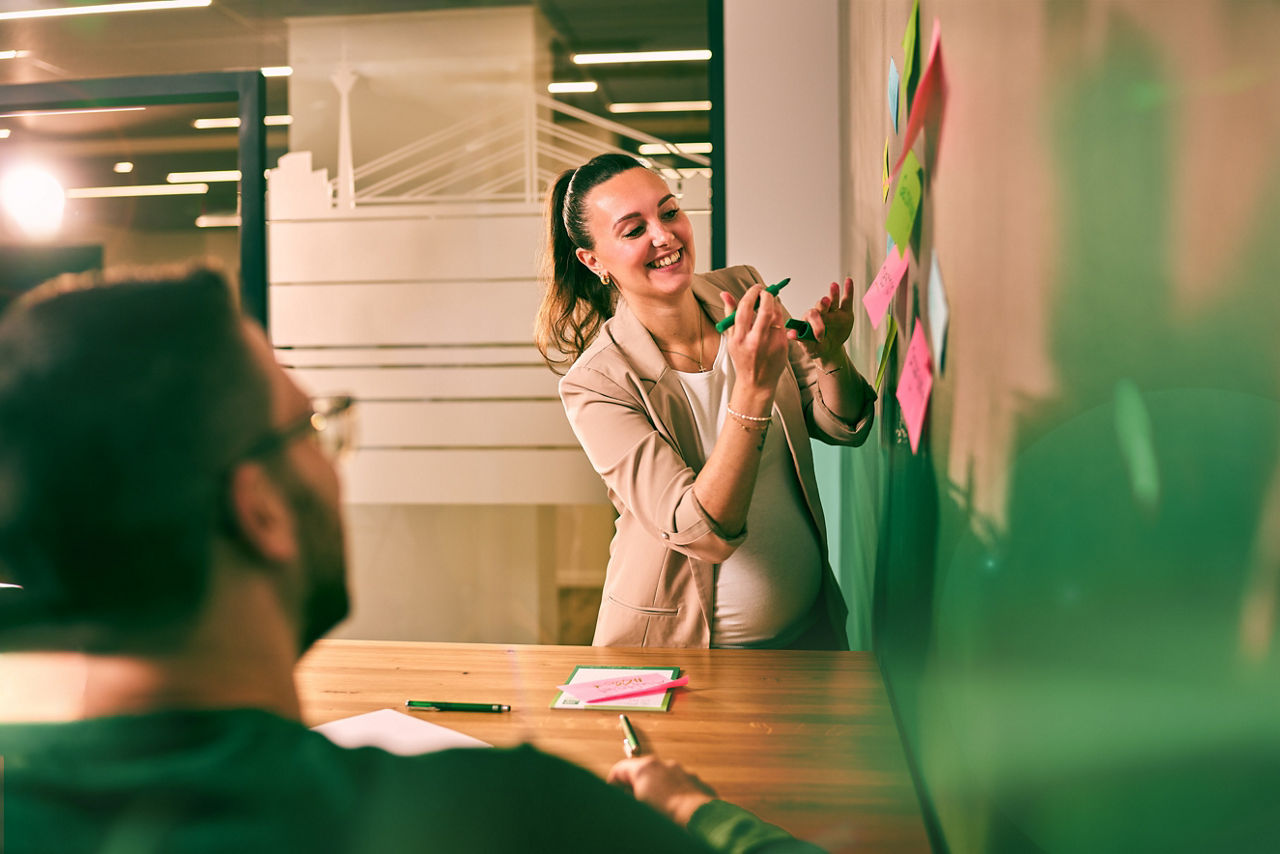Mann erklärt Teilnehmern einer Fortbildung etwas auf einem Flipchart