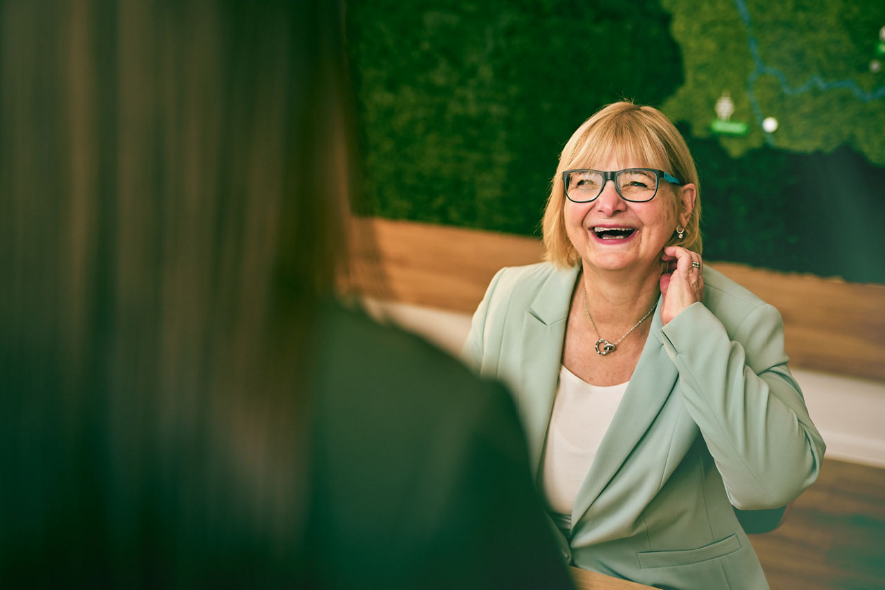 Frau mit Brille lacht herzlich.