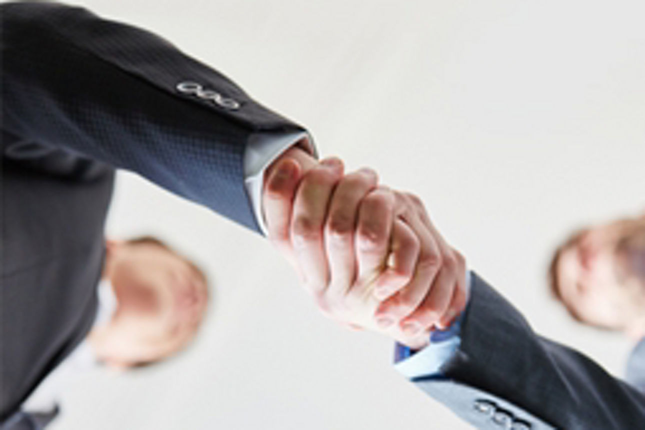 Zwei Geschäftsleute schütteln sich in einer formellen Umgebung die Hände