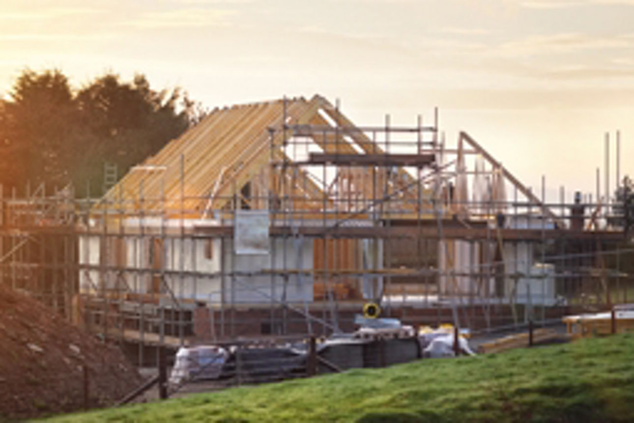 Ein im Bau befindliches Haus, umgeben von Baugerüsten, die auf laufende Bauarbeiten und Renovierungen hinweisen.