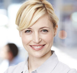 Eine Frau mit einem warmen Lächeln, das ihre Freude und Positivität zum Ausdruck bringt.