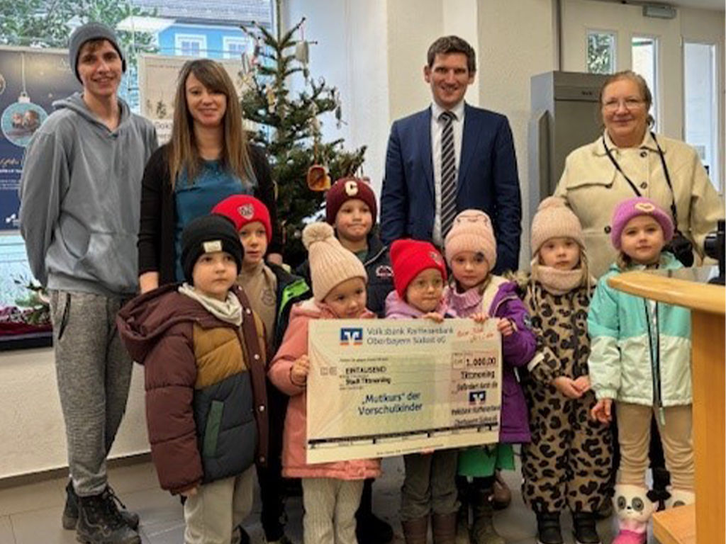 Filialleiterin Christina Demm und Bereichsleiter Daniel Schader übergeben den Spendenscheck an den Kindergarten Tittmoning.