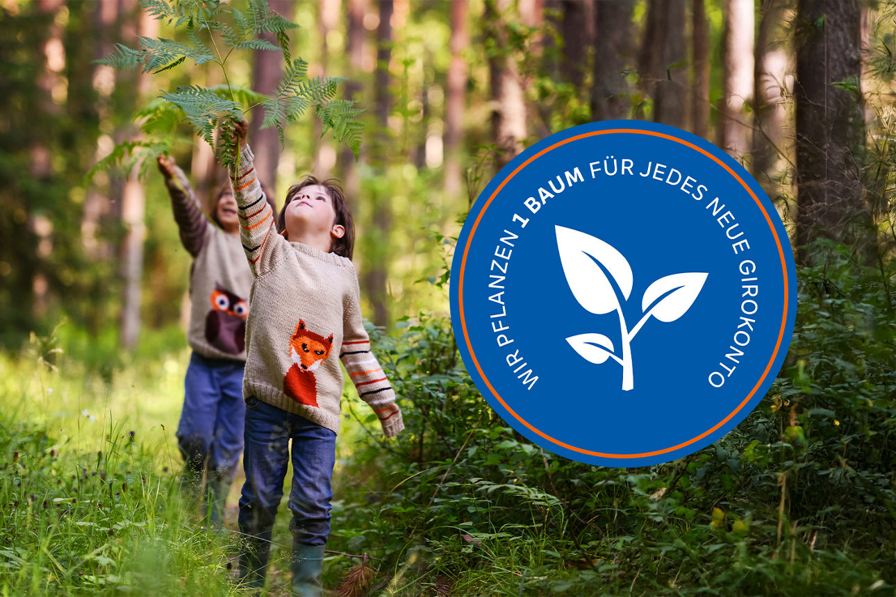 Zwei Kinder spielen im Wald und strecken sich nach einem Baumzweig