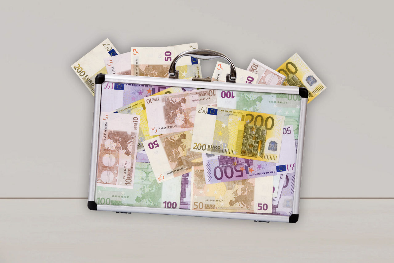 Transparenter Koffer mit Geldscheinen vor einem hellen Hintergrund
