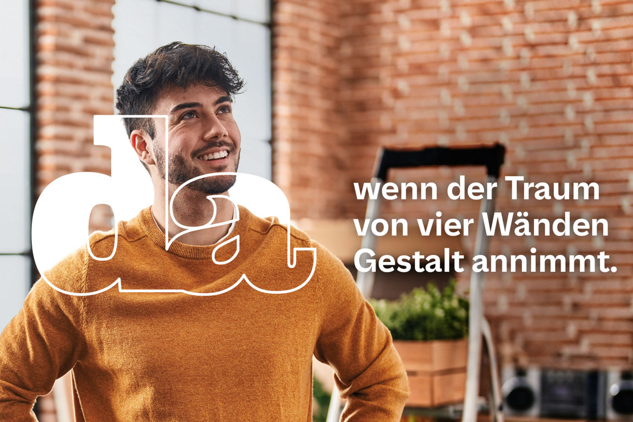 Junger Mann in neuer Wohnung steht zufrieden zwischen Umzugskartons mit den Händen in der Hüfte und blickt optimistisch