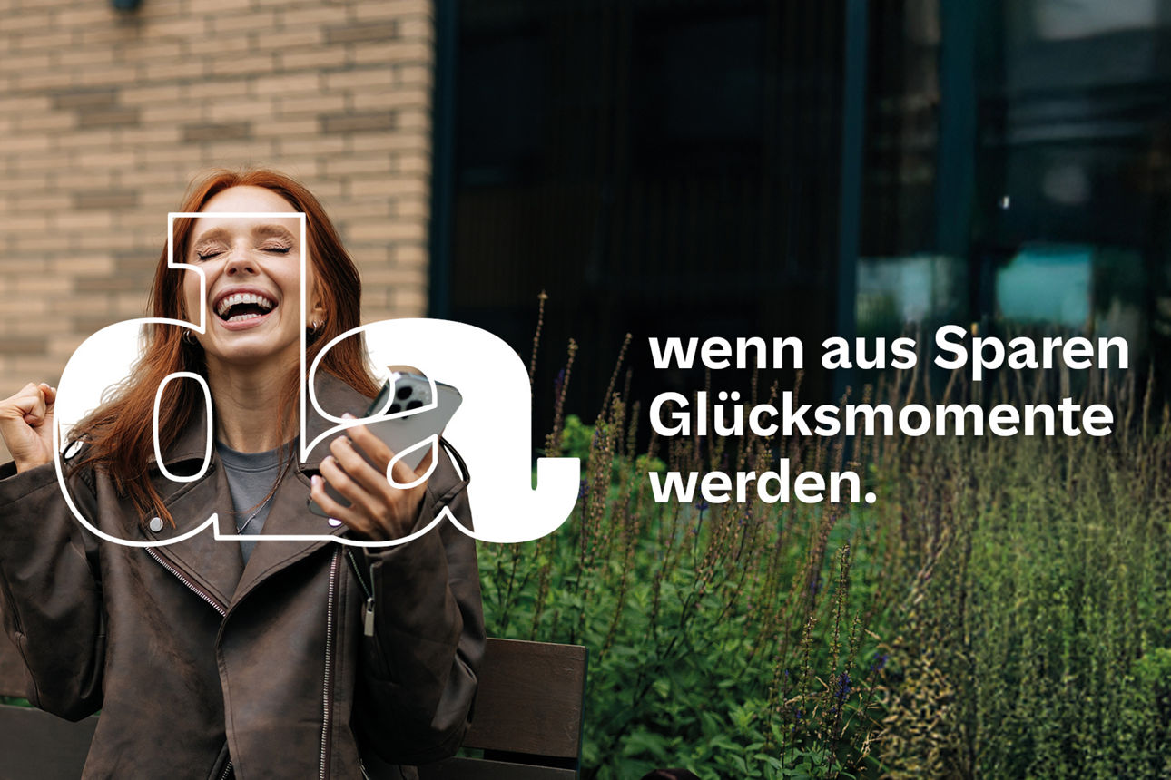 Junge Frau sitzt auf einer Parkbank vor einem Bürogebäude freut sich ausgelassen mit Smartphone in der Hand