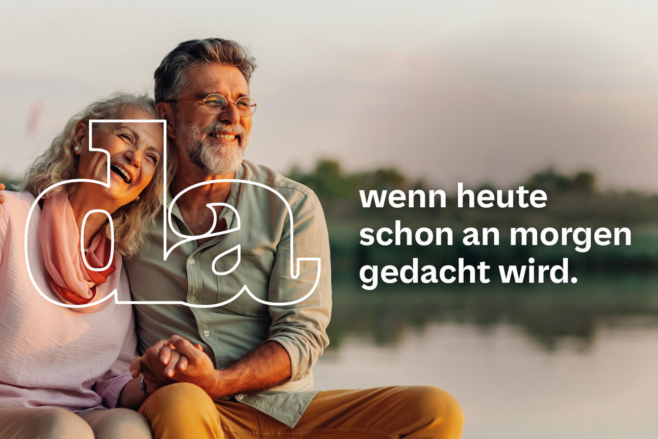 Älteres Paar sitzt eng umschlungen am Bug eines Boots hält Händchen und lacht gemeinsam während die Sonne untergeht