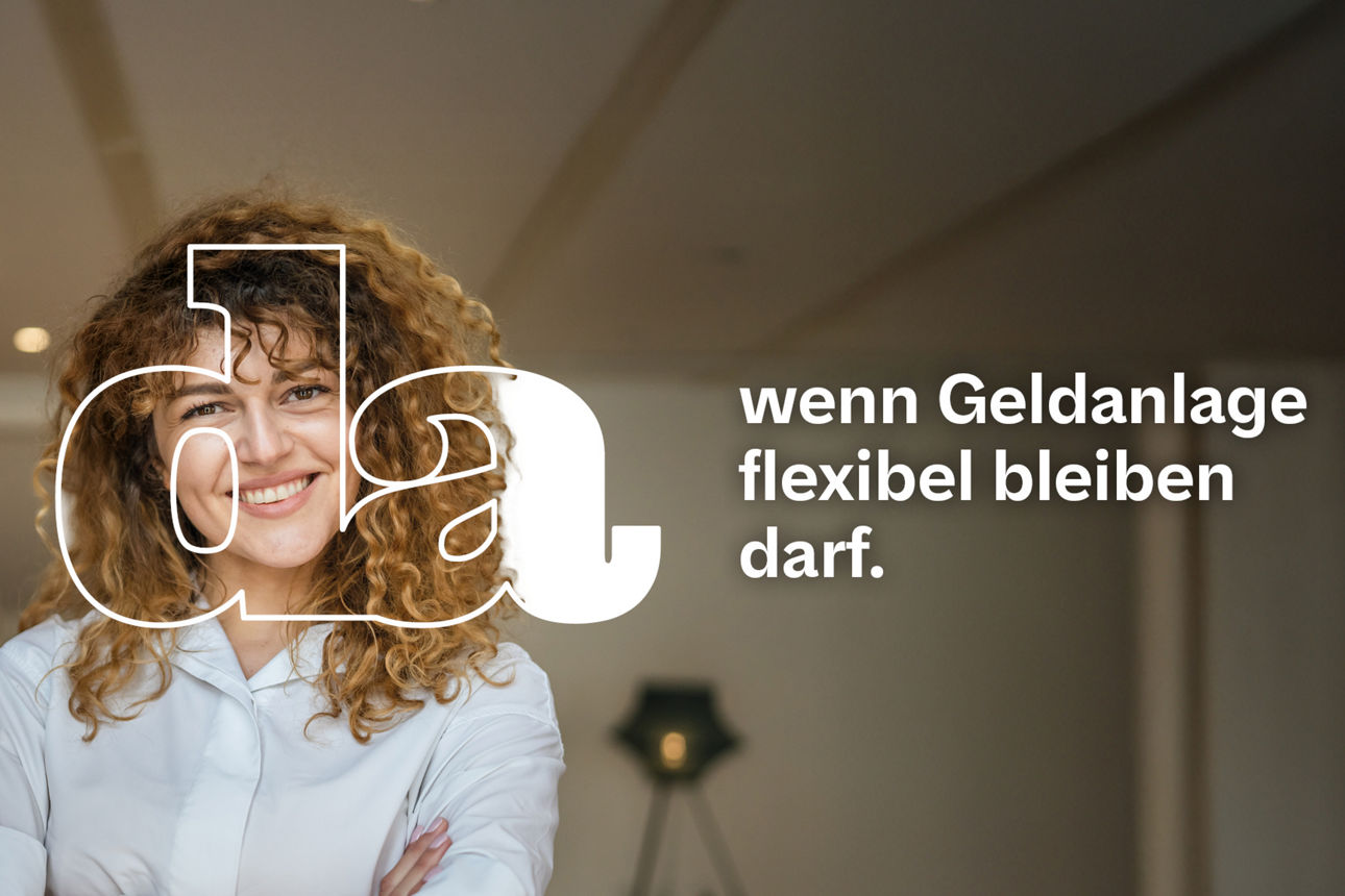 Selbstbewusste Frau mit lockigem Haar steht lächelnd mit verschränkten Armen in einem stilvoll eingerichteten Raum