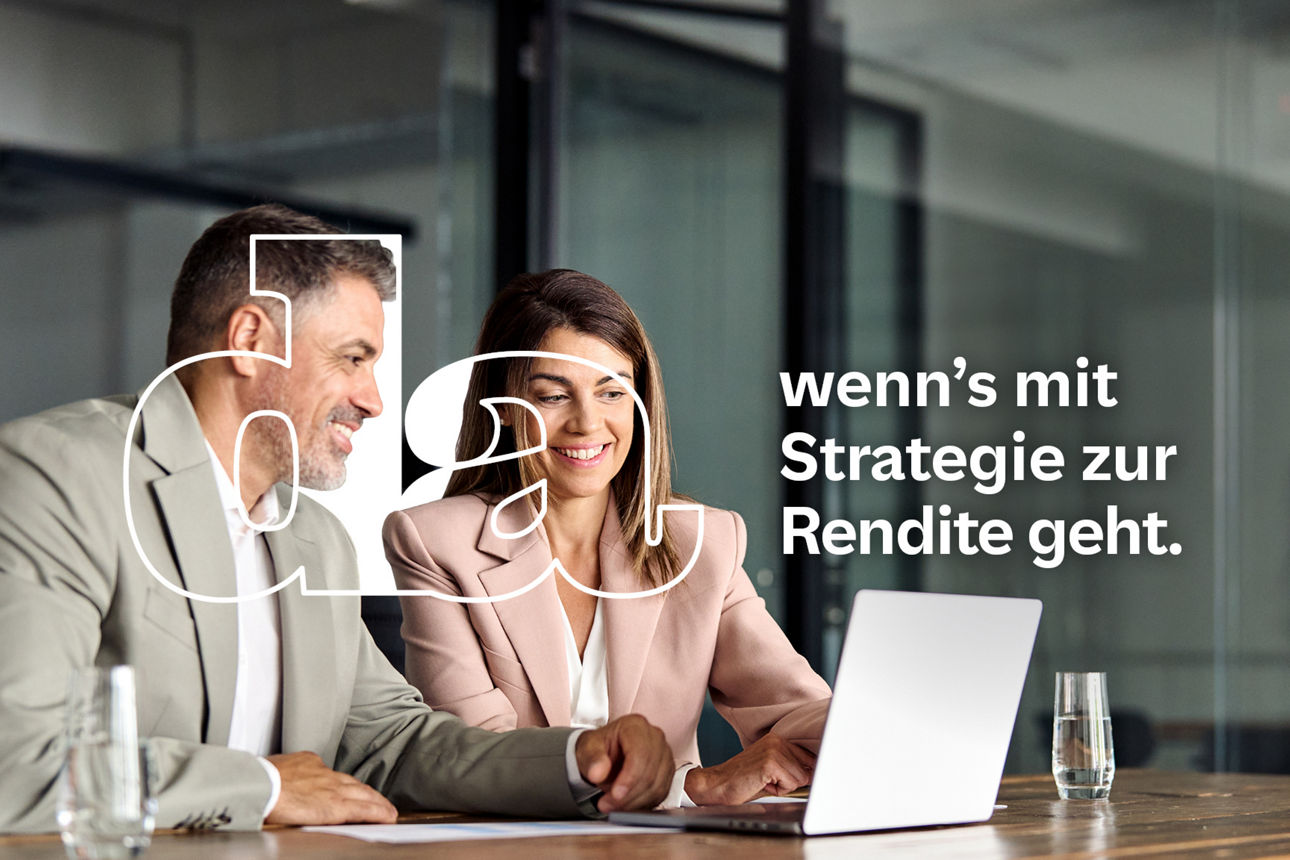 Ein Business-Mann und eine Business-Frau sitzen gemeinsam an einem Tisch in einem modernen Büro und arbeiten