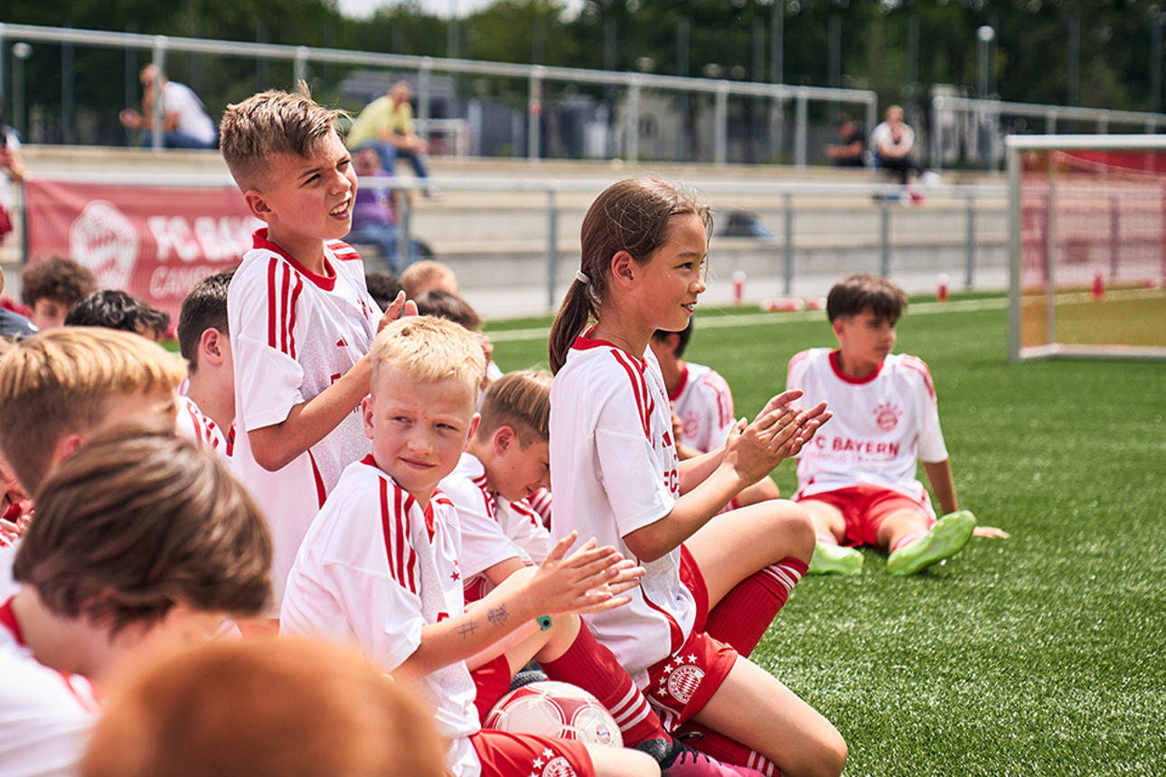 Kinder in FC Bayern Jugendtrikots auf dem Fußballplatz