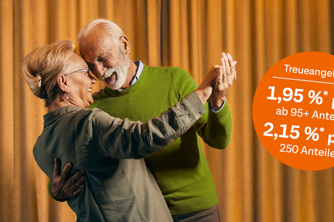 Ein Paar in hohem Alter tanzen vor einem orangenen Vorhang