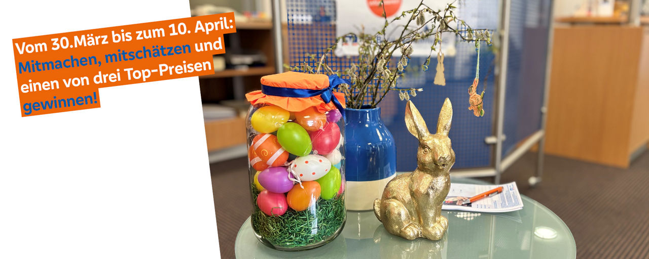 Ein Glas in welchem bunte Ostereier sind und ein goldener Osterhase der daneben steht