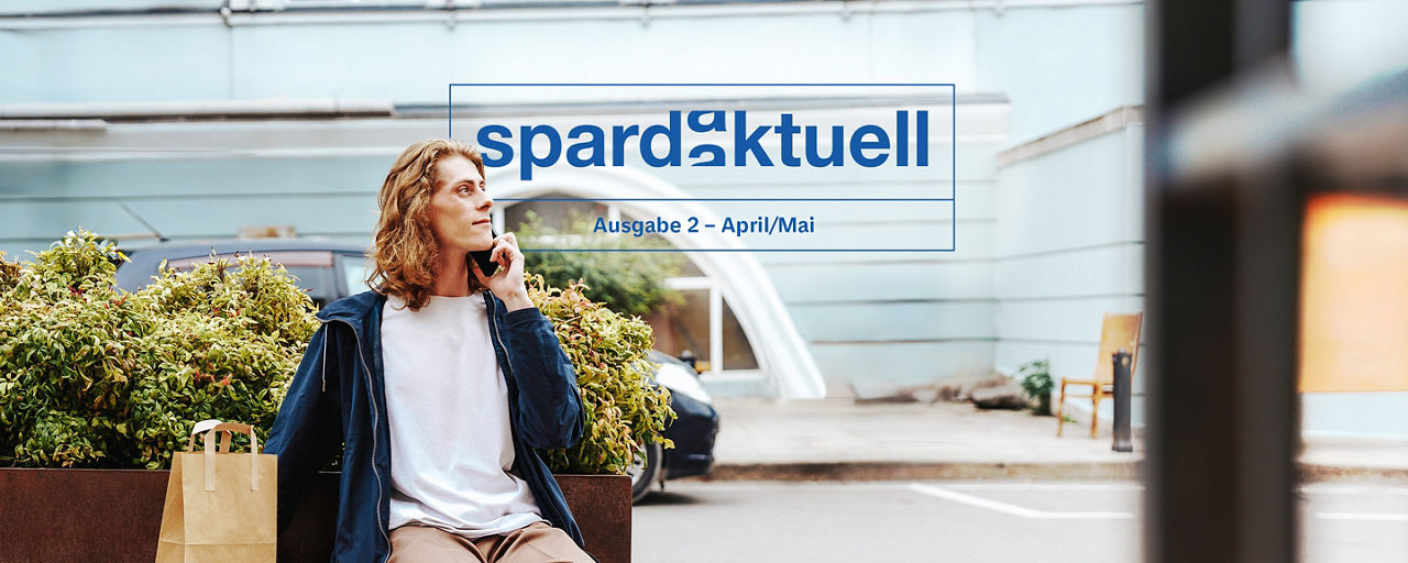 Mann sitzt mit Handy auf einer Bank 