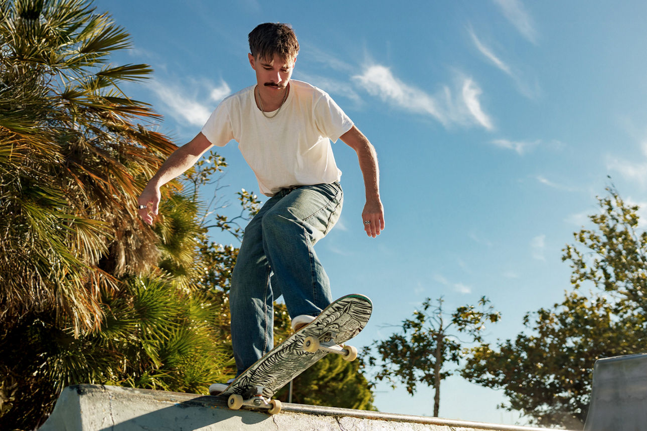 SpardaGiroYoung Jugendlicher steht auf einem Skateboard und fährt bergab.