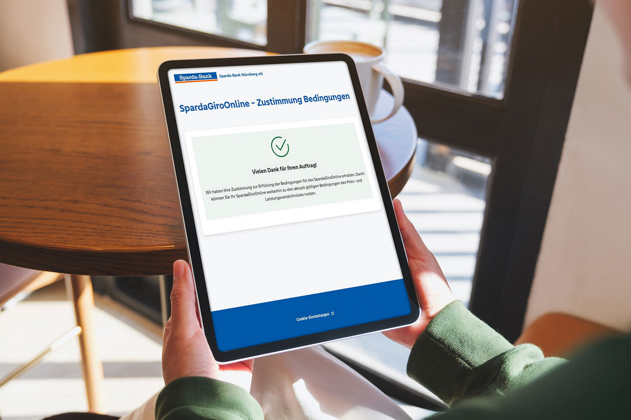Eine Person hält ein Tablet in der Hand. 