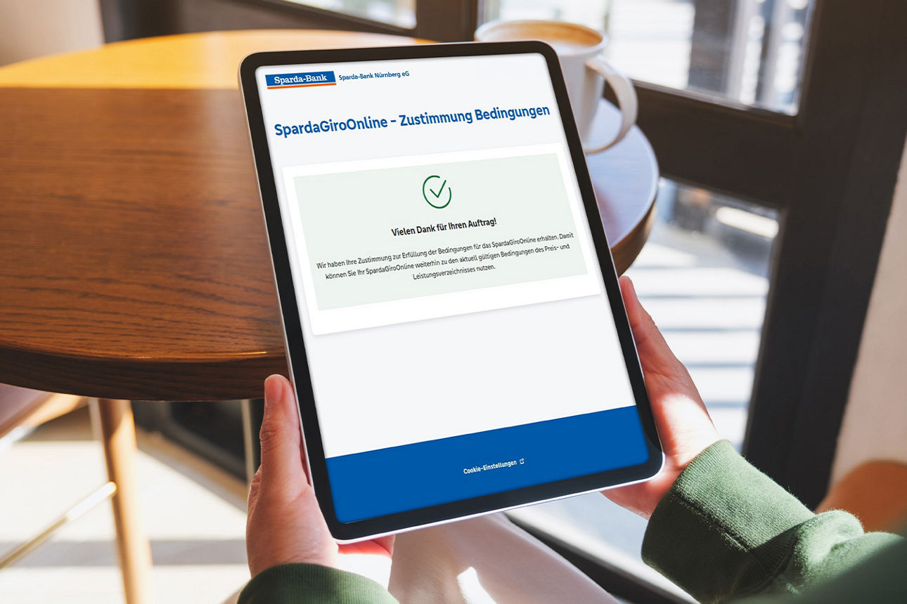 Eine Person hält ein Tablet in der Hand.
