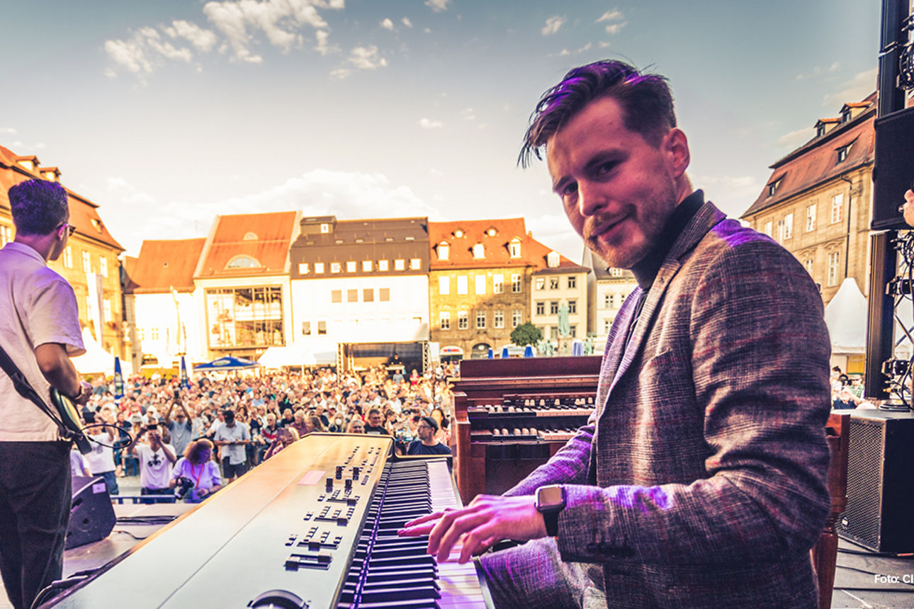 EIn Pianist auf eine Bühne vor zahlreichen Zuschauern