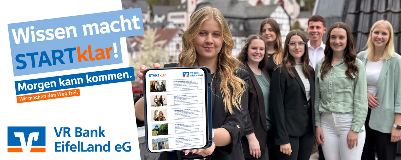 Mehrere Azubis sind auf dem Bild zusehen und eine steht vorne und hält ein Tablet in der Hand und streckt es in die Kamera